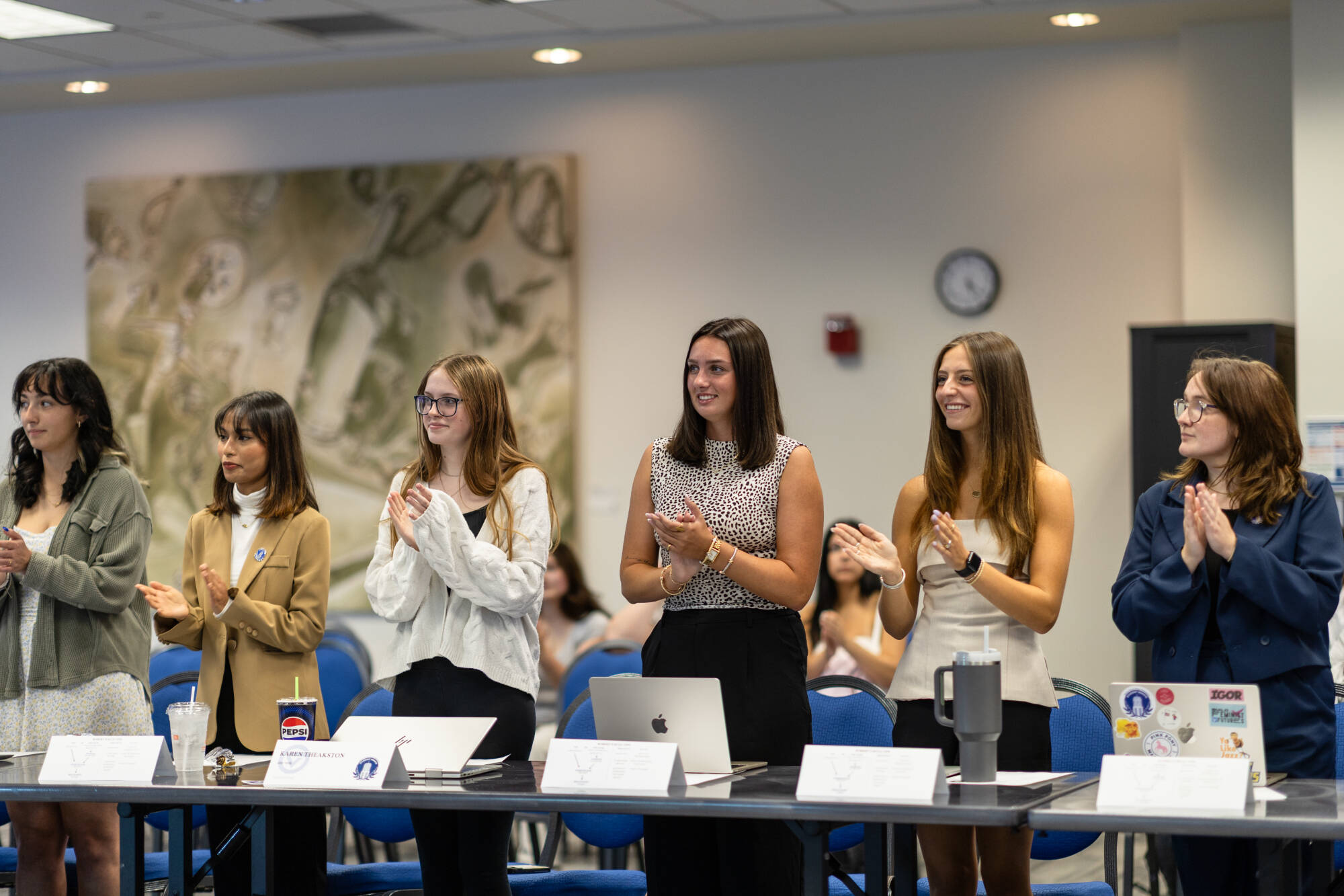 Student Senators standing and clapping during a General Assembly meeting.